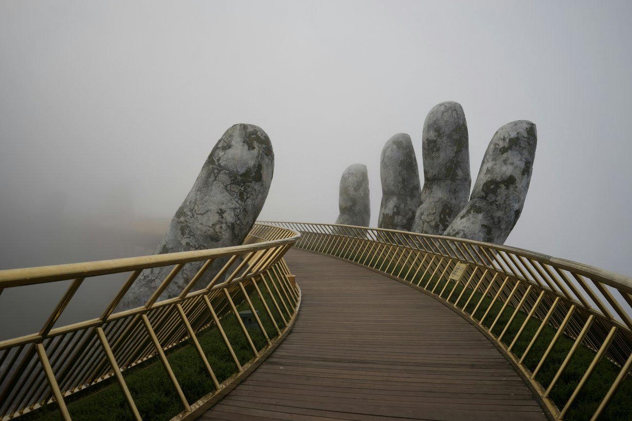 Photo of a bridge with a sculpture of a hand around it